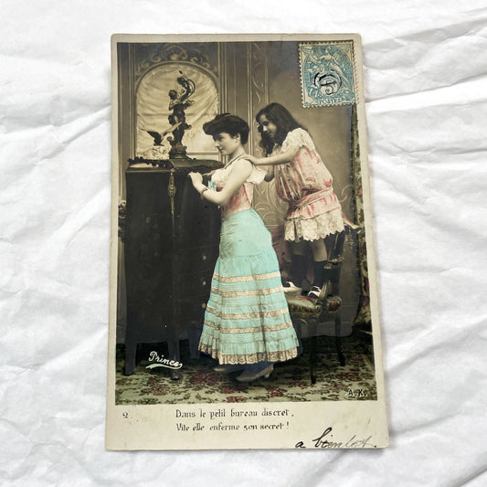 1900s - French Hand Colored Postcard - Young Woman Locking Secret in Discreet Cabinet - Charming Belle Epoque Genre Scene