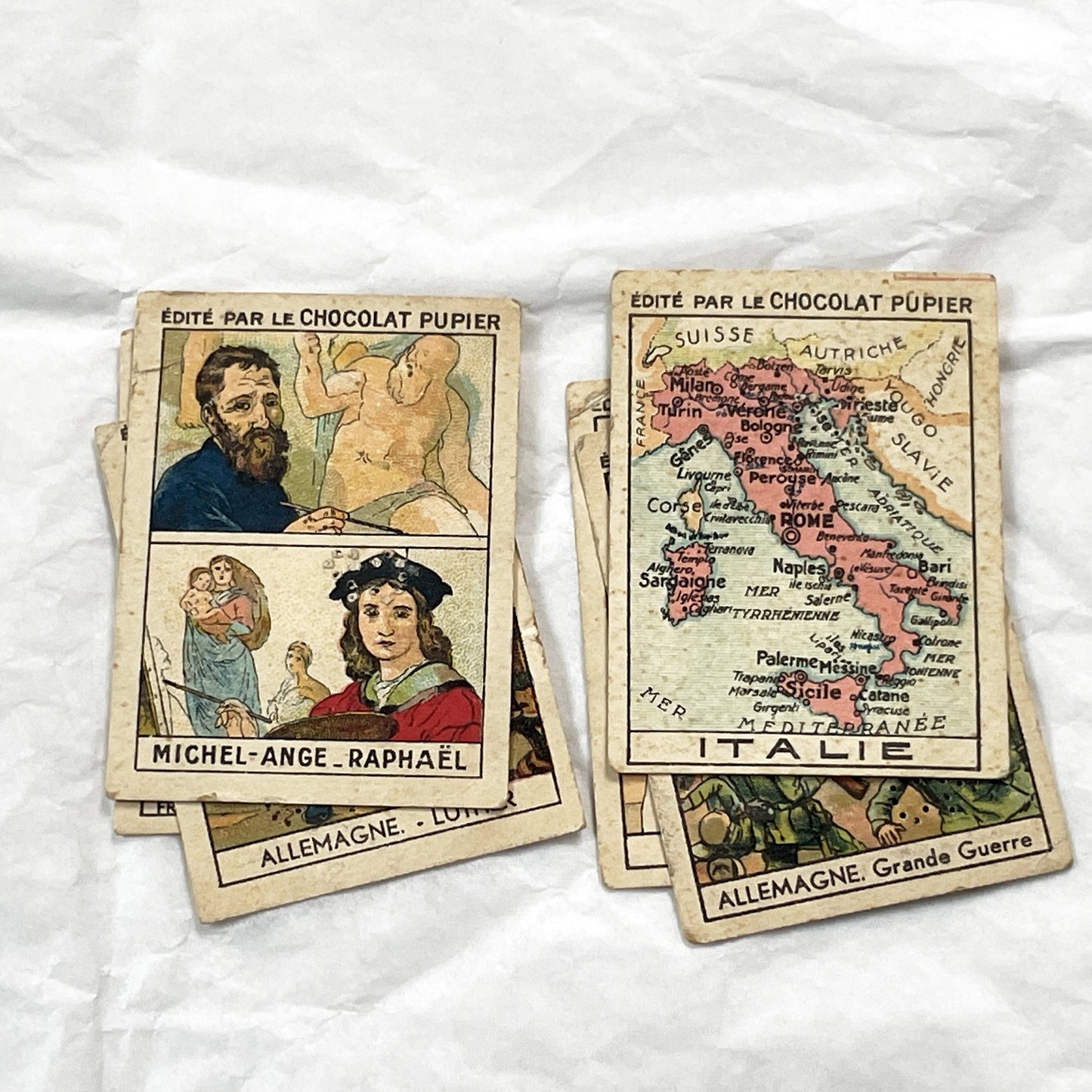 1910s - 10 Pupier Chocolate Trade Cards - Historical Figures and Cultural Heritage - Germany, Italy, Zeppelin, WWI, Art, Military, Cities