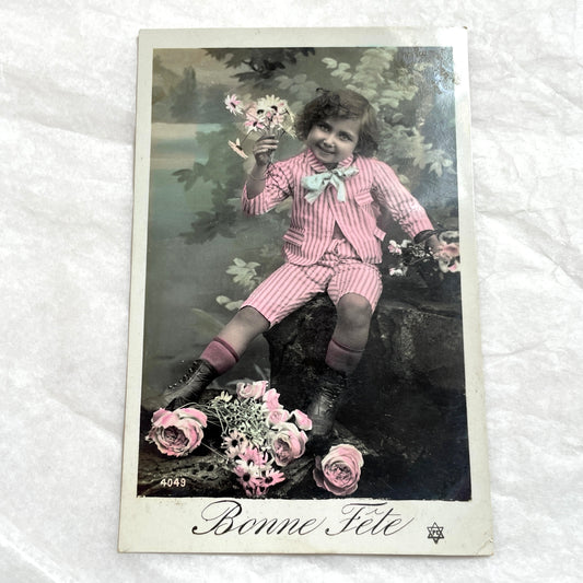 1900s - Vintage Postcard of Child with Flowers - Bonne Fête Greeting