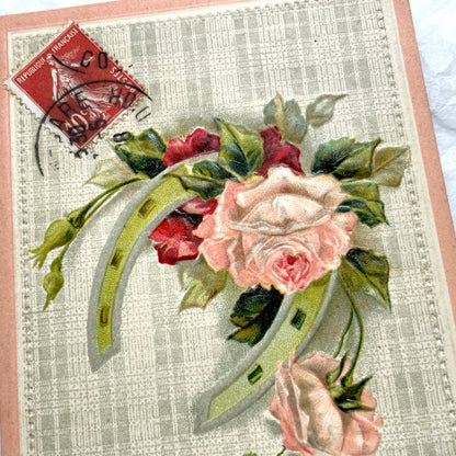 1900s French postcard with embossed pink roses and a green lucky horseshoe on a plaid background.