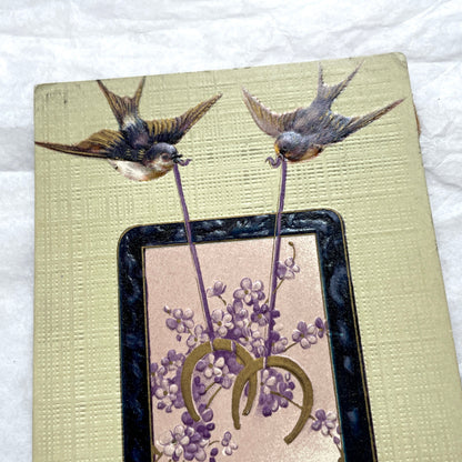 1900s New Year postcard with swallows carrying a good luck horseshoe and 'Bonne année' French text.