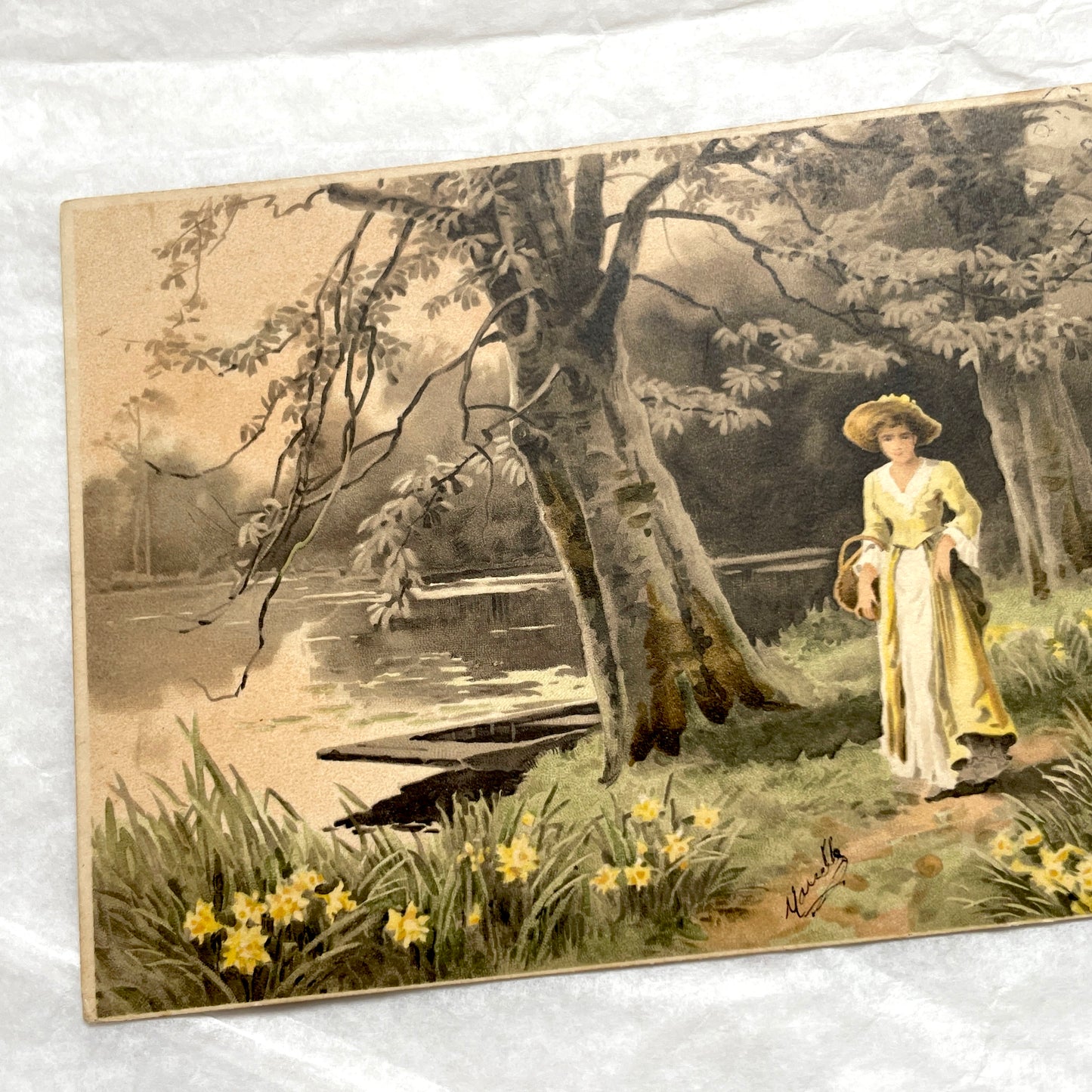 1900s French postcard depicting a woman in a yellow dress walking through a field of daffodils.