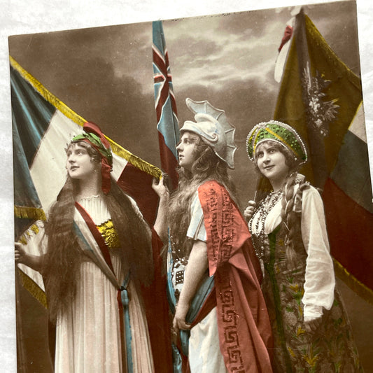 1910s French WWI postcard featuring three allegorical women representing France, Britain, and Russia with flags.