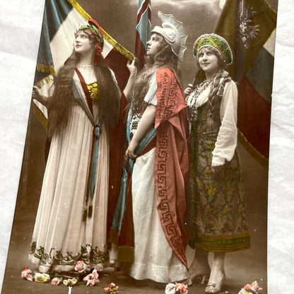 1910s French WWI postcard featuring three allegorical women representing France, Britain, and Russia with flags.