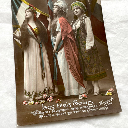 1910s French WWI postcard featuring three allegorical women representing France, Britain, and Russia with flags.