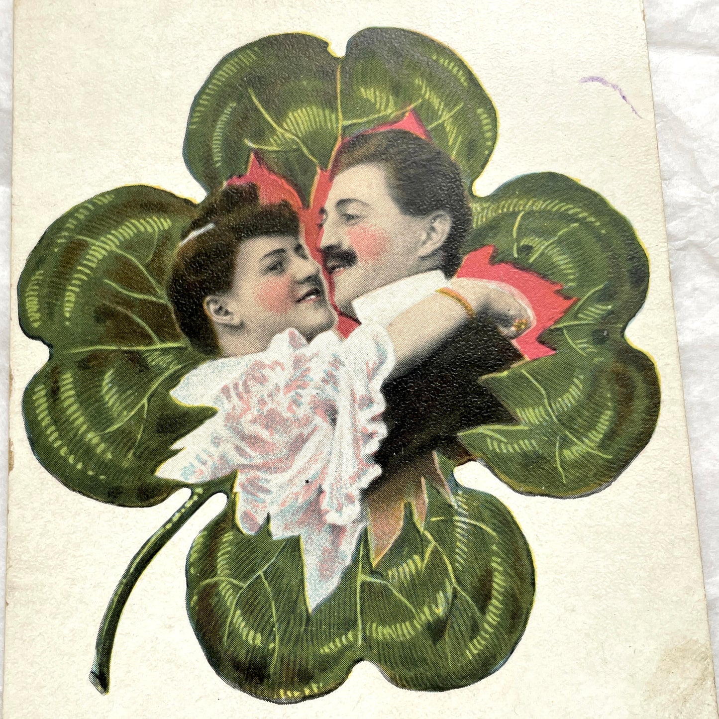 1900s postcard with a romantic couple embracing inside a green four-leaf clover, French New Year greeting.