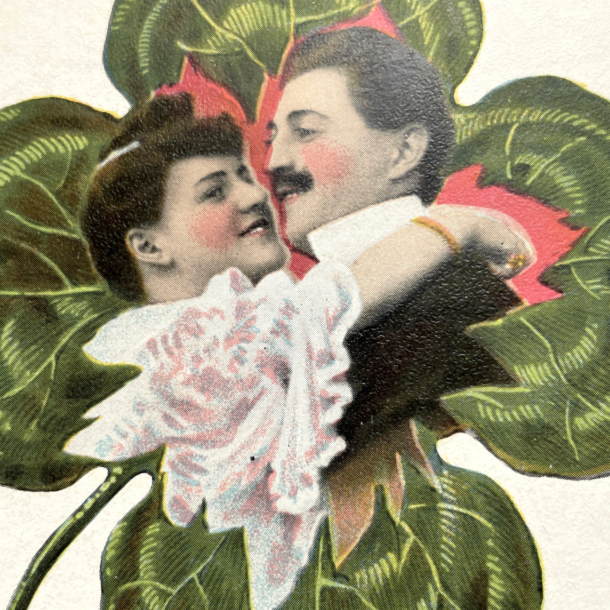 1900s postcard with a romantic couple embracing inside a green four-leaf clover, French New Year greeting.