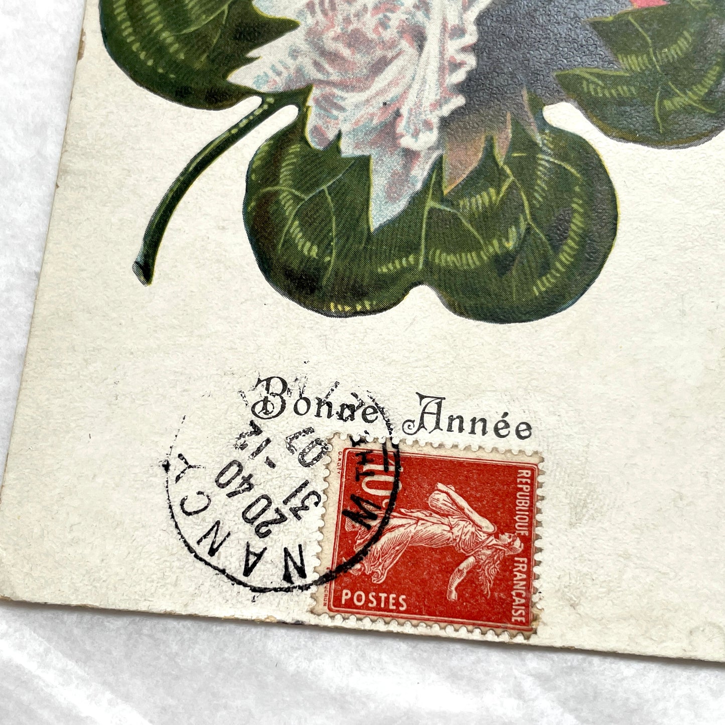 1900s postcard with a romantic couple embracing inside a green four-leaf clover, French New Year greeting.
