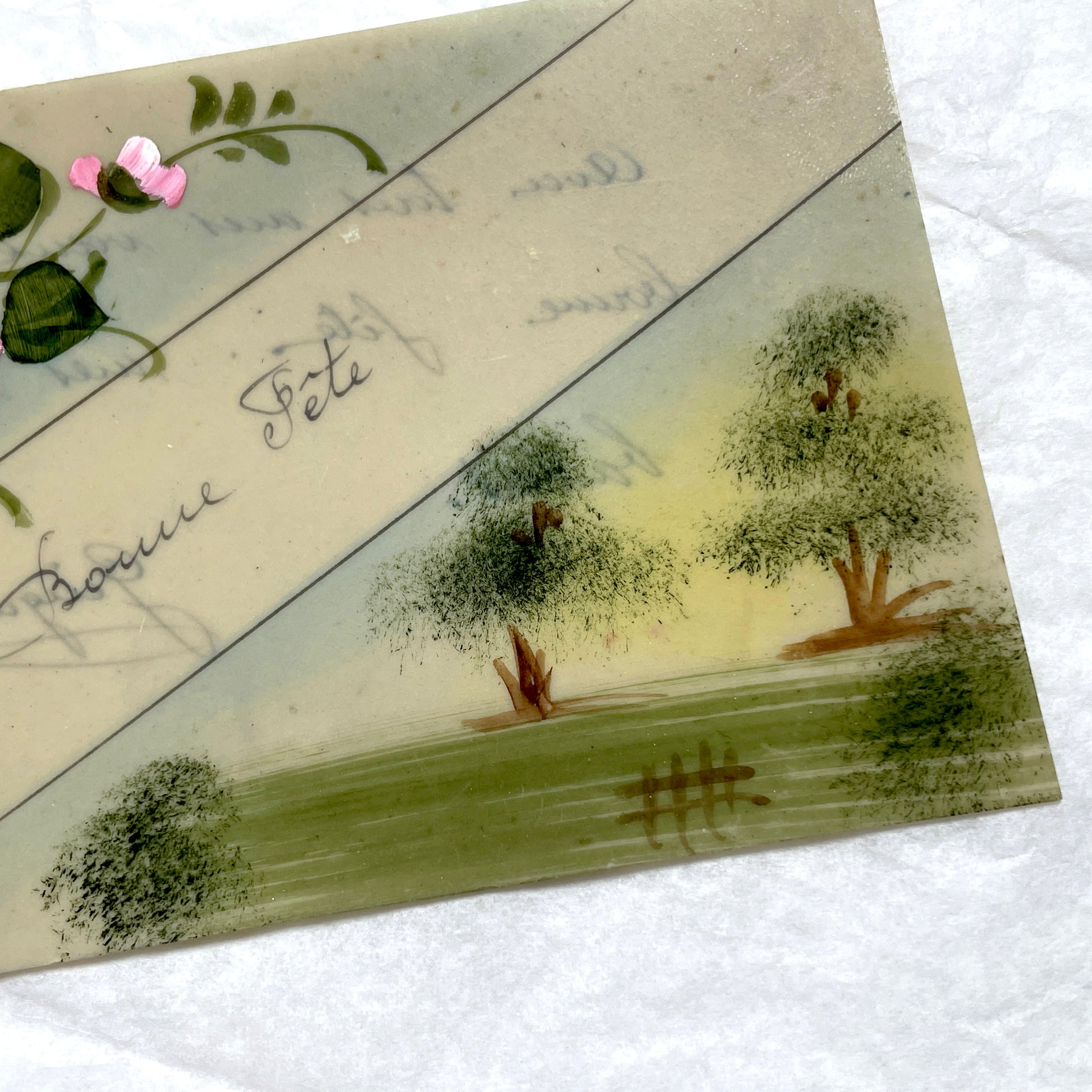 1910s French greeting card with hand-painted pink rose, green leaves, and rustic landscape scene.