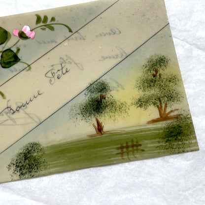 1910s French greeting card with hand-painted pink rose, green leaves, and rustic landscape scene.