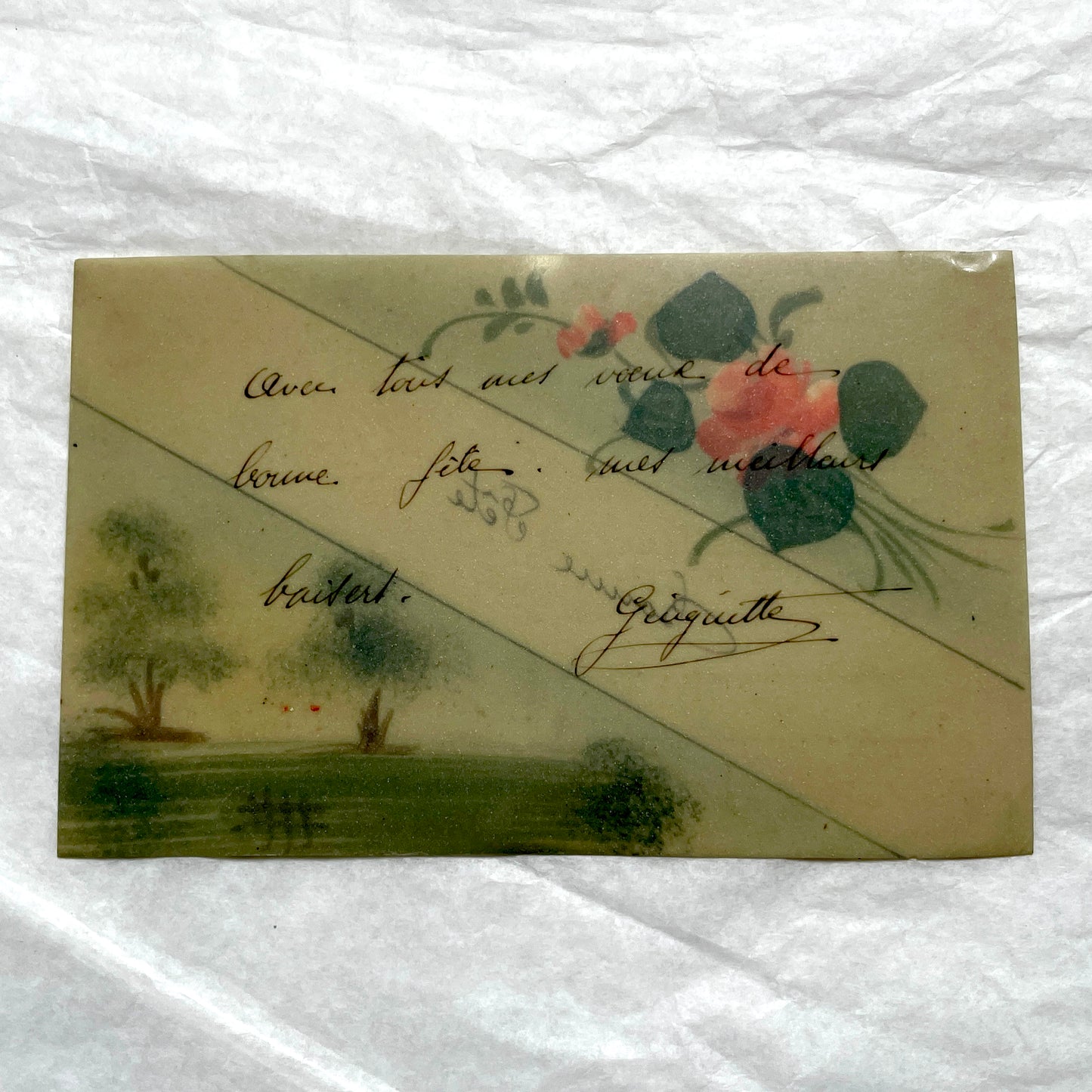 1910s French greeting card with hand-painted pink rose, green leaves, and rustic landscape scene.