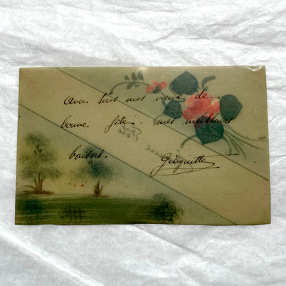 1910s French greeting card with hand-painted pink rose, green leaves, and rustic landscape scene.