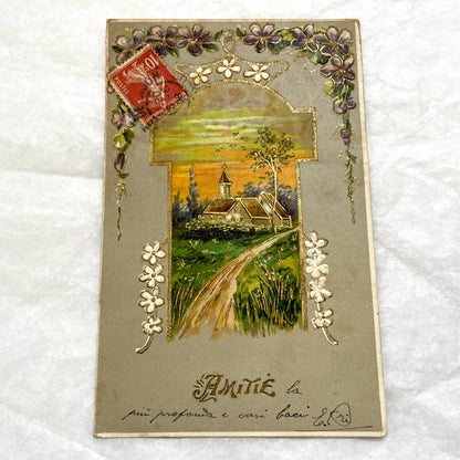 1900s French postcard featuring a gilded church landscape, floral border, and an antique 10c Postes stamp.