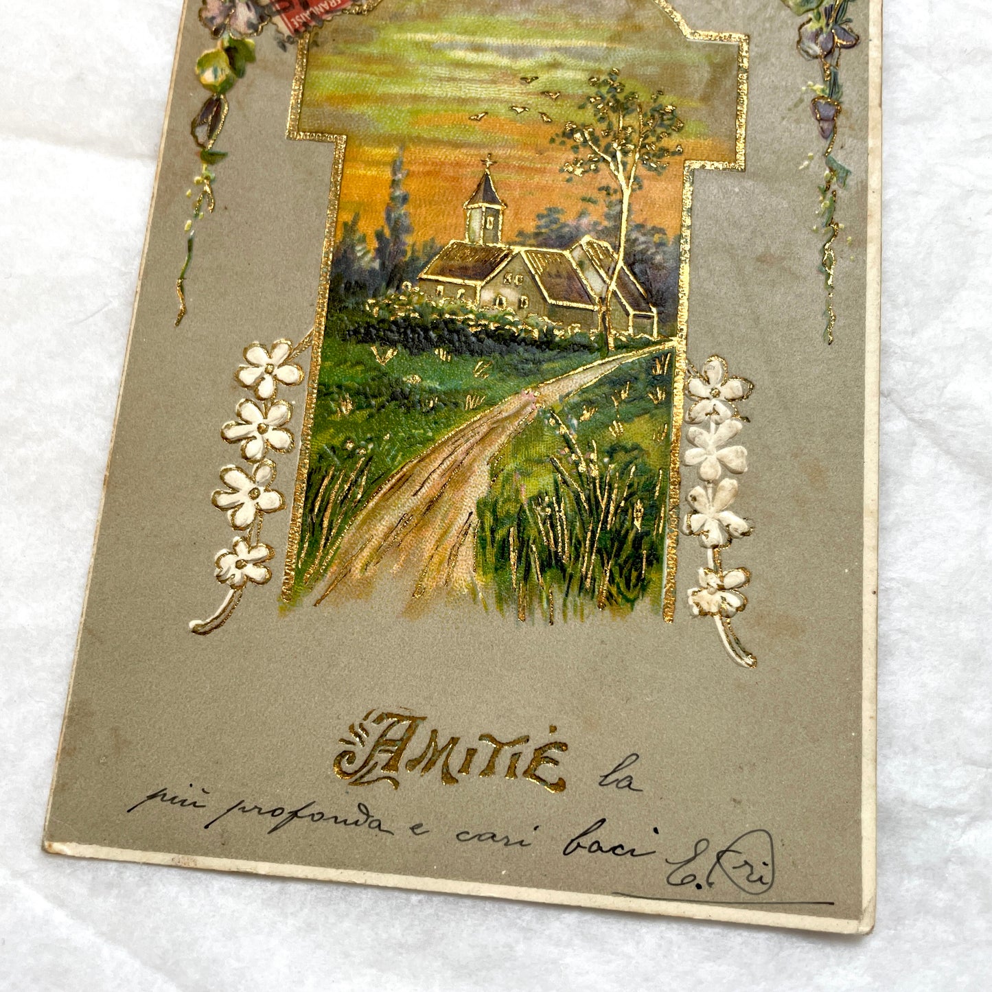 1900s French postcard featuring a gilded church landscape, floral border, and an antique 10c Postes stamp.