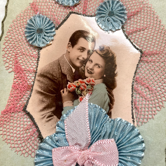 1940s French greeting card featuring a romantic couple's photo, blue pleated ribbon, and 'Bonne Fête' banner.