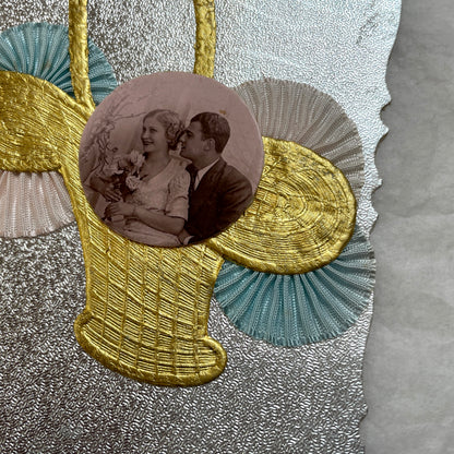 1930s vintage decorative card with a sepia wedding couple photo, golden embossed basket, and pastel ribbons on silver.