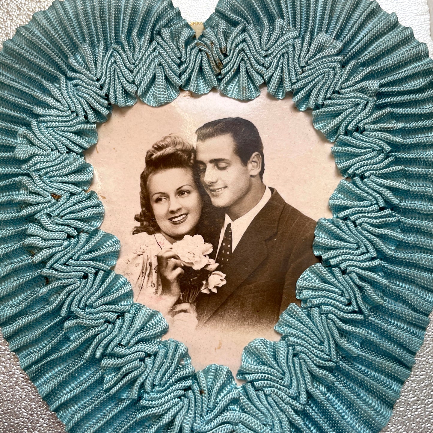 1940s French postcard with a sepia photo of a couple, framed by a blue ribbon heart and romantic French text.