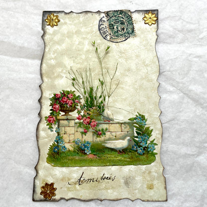 1900s Antique French greeting card with embossed doves, pink roses, blue forget-me-nots, and original postal stamp.