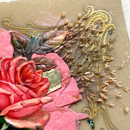 1900s French postcard with embossed hand holding pink roses, green glitter, and ornate gold frame.