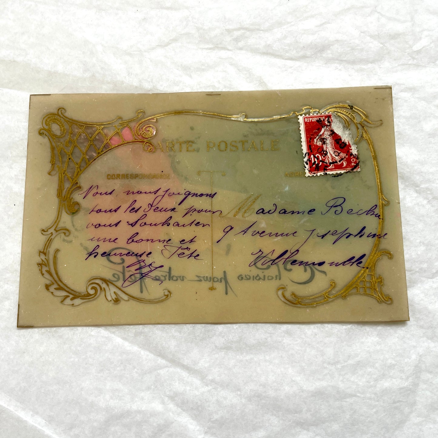 1900s French postcard with embossed hand holding pink roses, green glitter, and ornate gold frame.