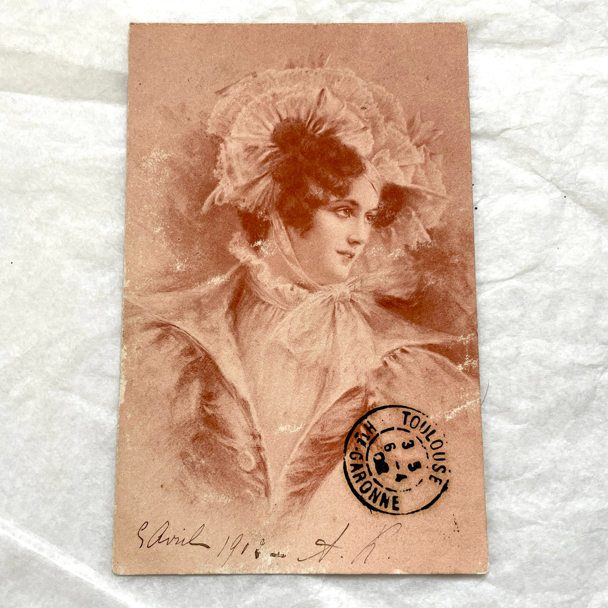 1900s French postcard with an elegant woman wearing a large, fashionable hat, stamped with a Toulouse postmark.