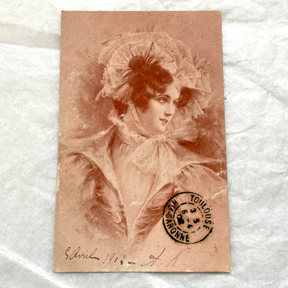 1900s French postcard with an elegant woman wearing a large, fashionable hat, stamped with a Toulouse postmark.