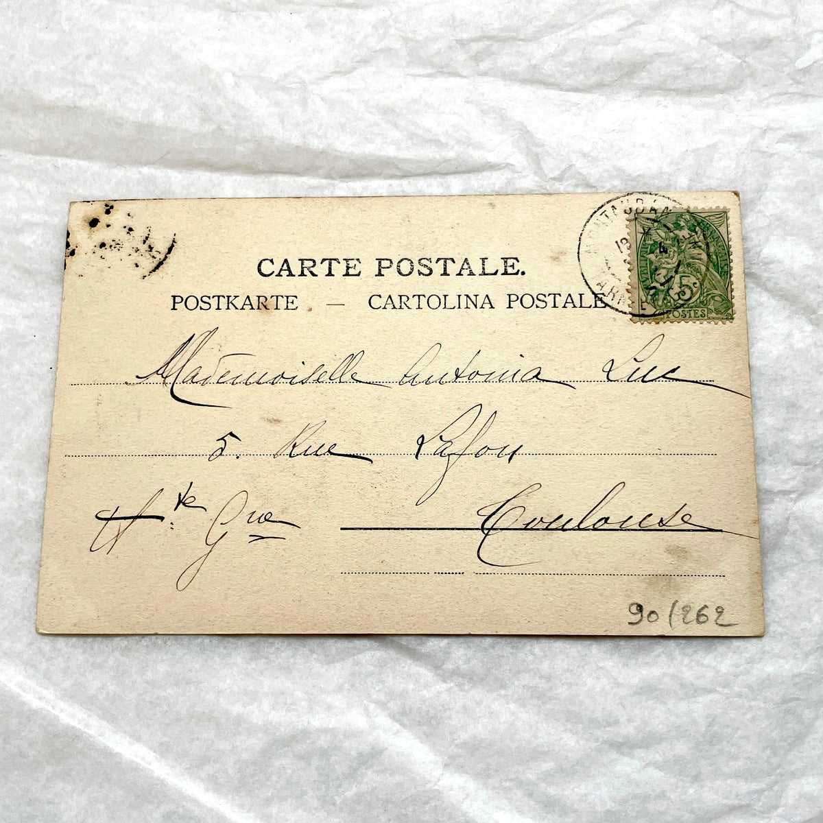 1900s French postcard with an elegant woman wearing a large, fashionable hat, stamped with a Toulouse postmark.