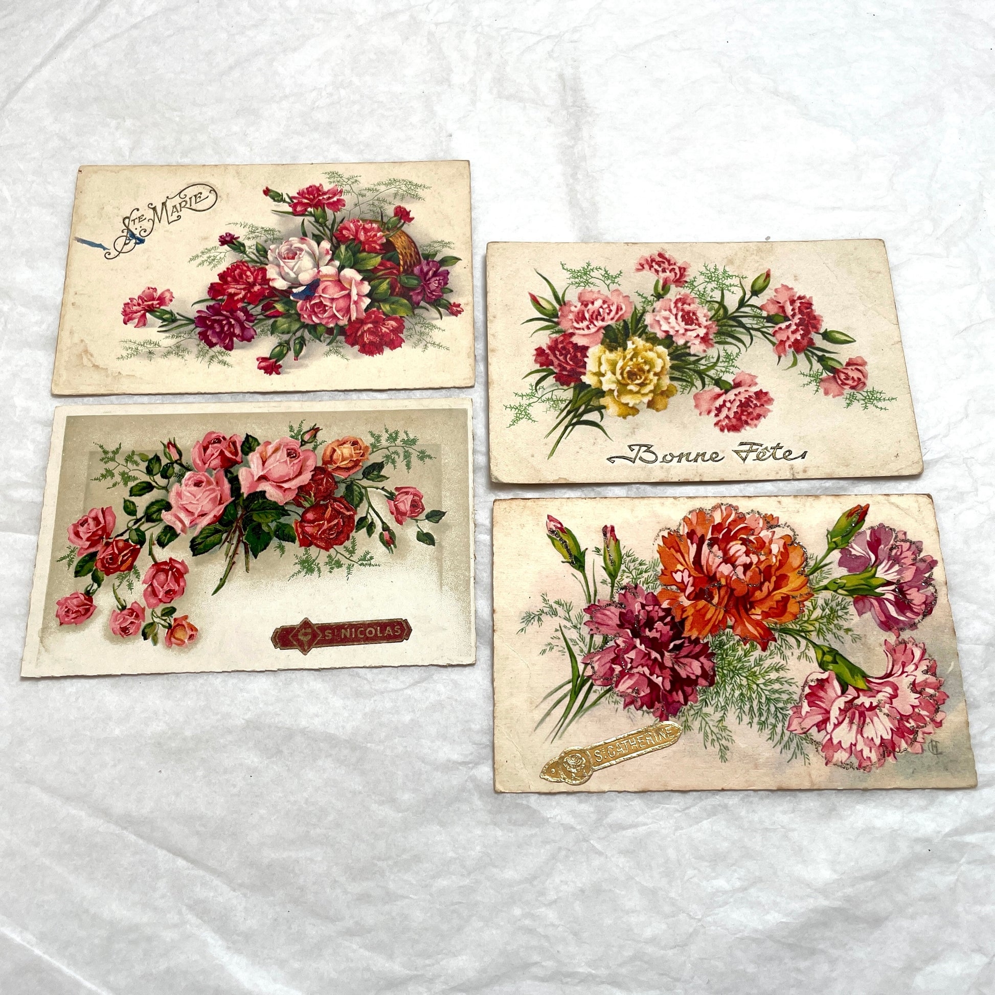 1900s French postcard lot showcasing four antique floral designs, including roses, carnations, and elegant French script.
