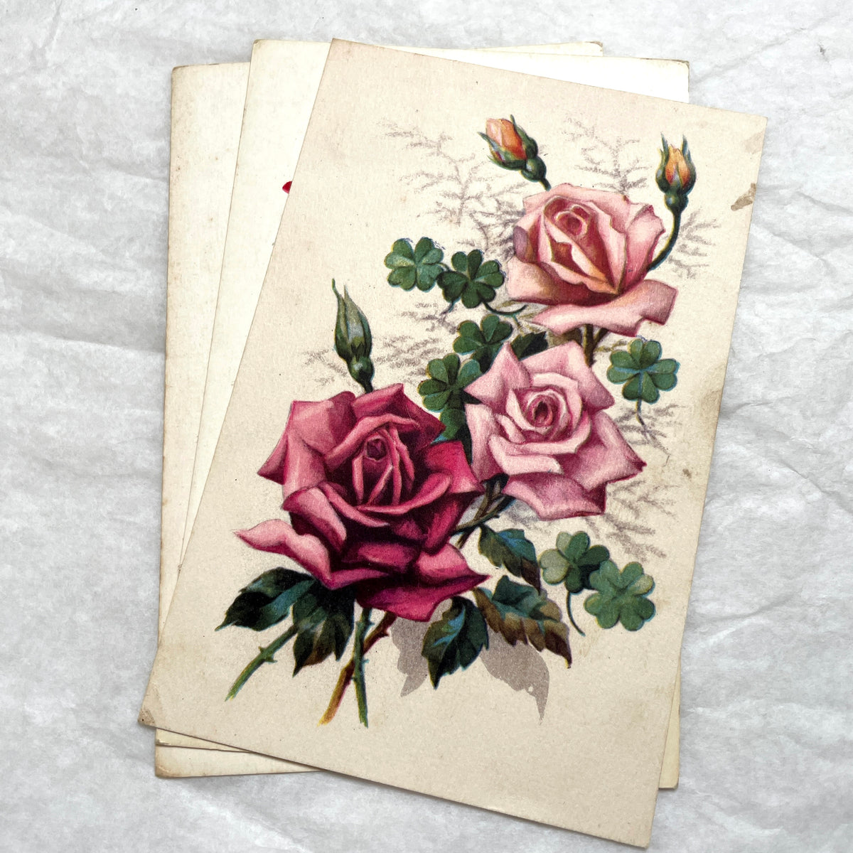 1930s vintage postcard lot featuring four unique illustrations of vibrant red and pink roses with green leaves, floral art.