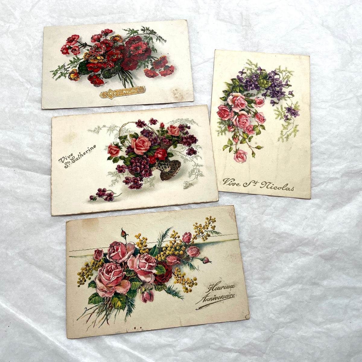 1900s French postcards lot with glitter floral designs and French text, vintage paper ephemera.