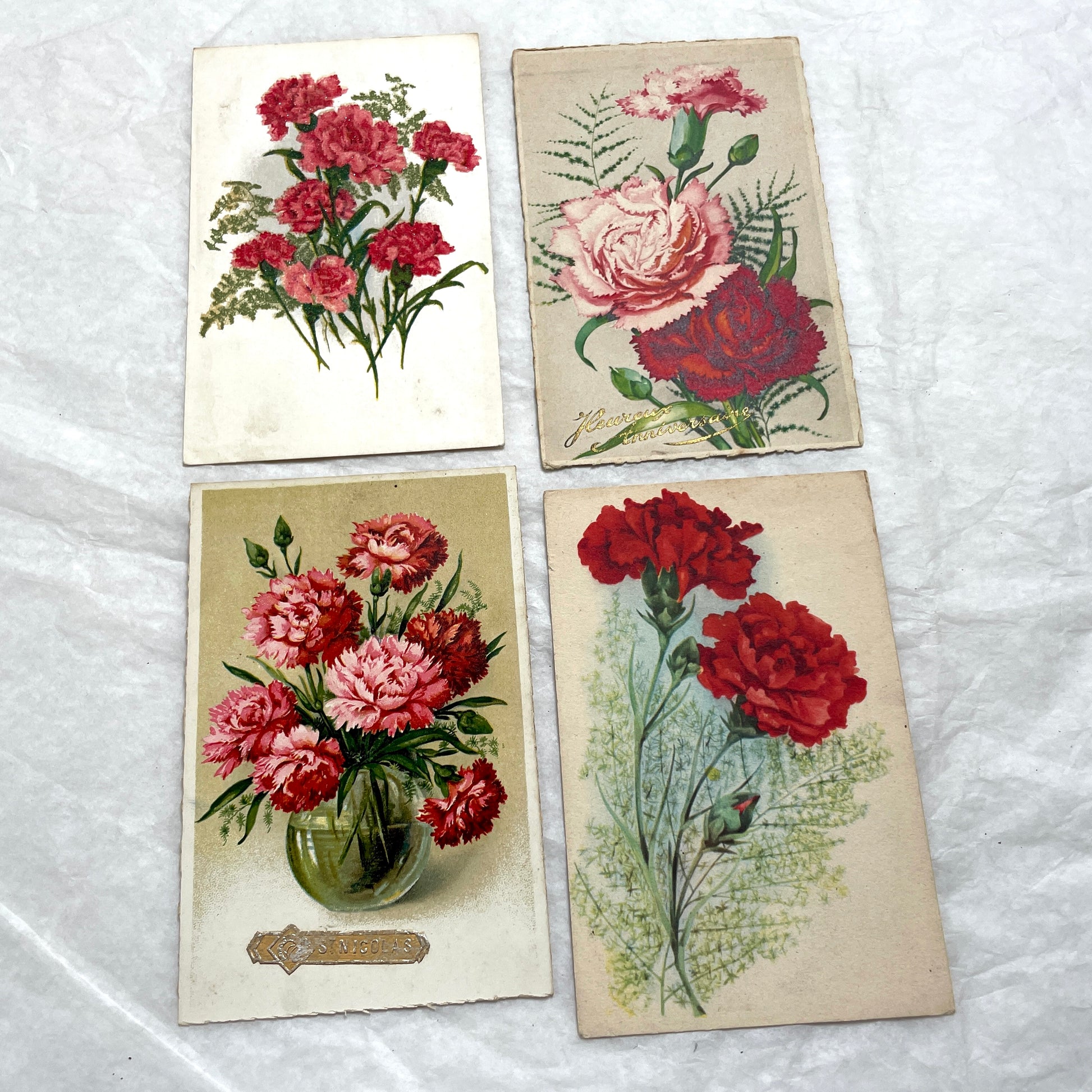 Lot of four 1950s carnation postcards featuring vibrant red and pink floral arrangements with French text.