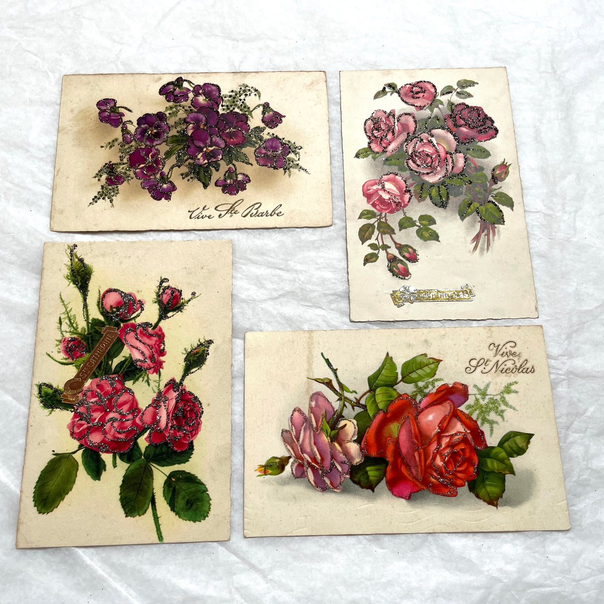 1910s French glitter postcard lot with purple pansies, pink roses, and red rose bouquets.