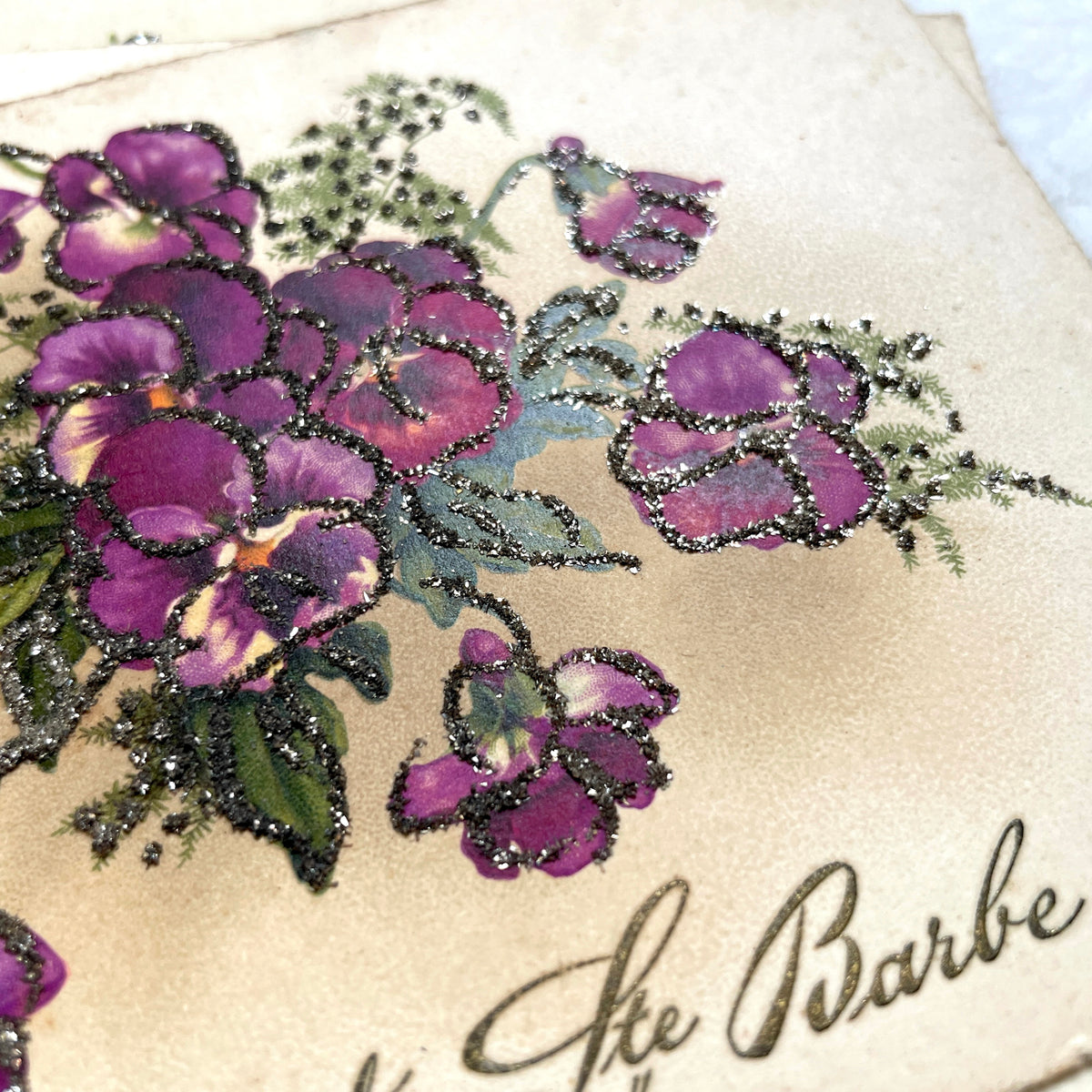 1910s French glitter postcard lot with purple pansies, pink roses, and red rose bouquets.