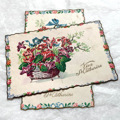 1950s French decorative card lot with floral baskets, glitter accents, and 'Vive Ste Catherine' inscription.