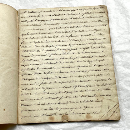 Late 19th Century handwritten French manuscript book with aged pages open to reveal flowing script.