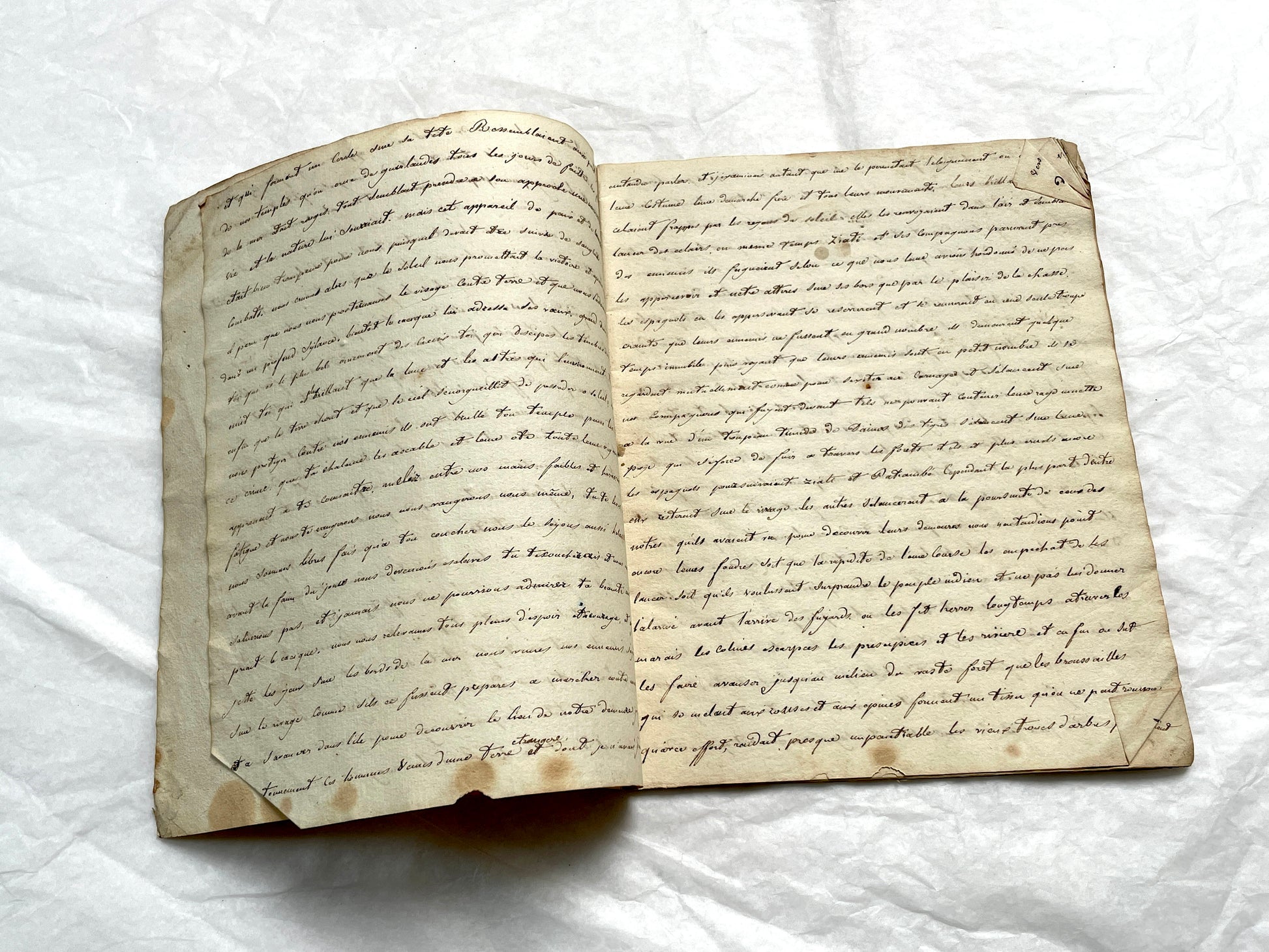 Late 19th Century handwritten French manuscript book with aged pages open to reveal flowing script.