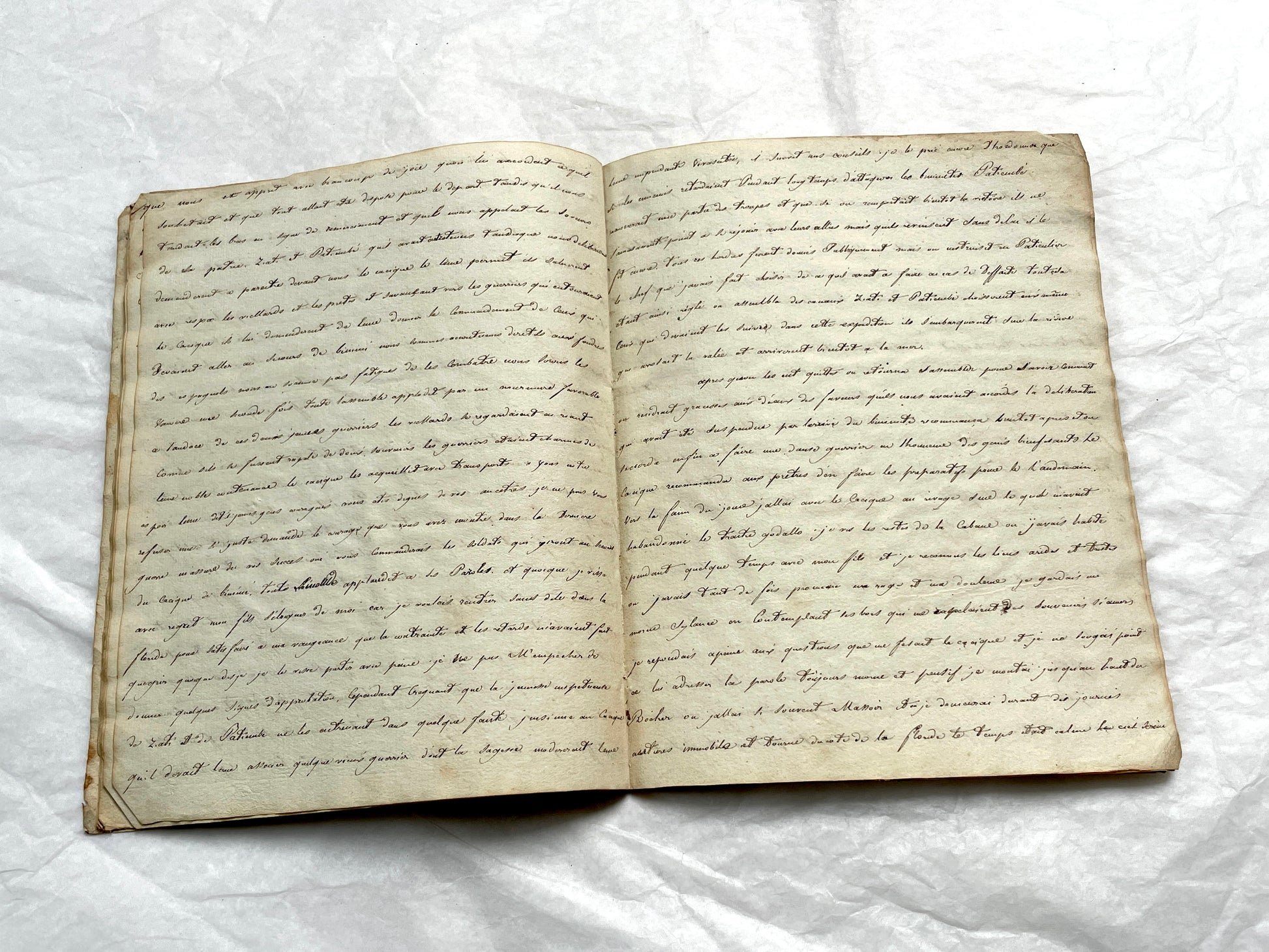 Late 19th Century handwritten French manuscript book with aged pages open to reveal flowing script.