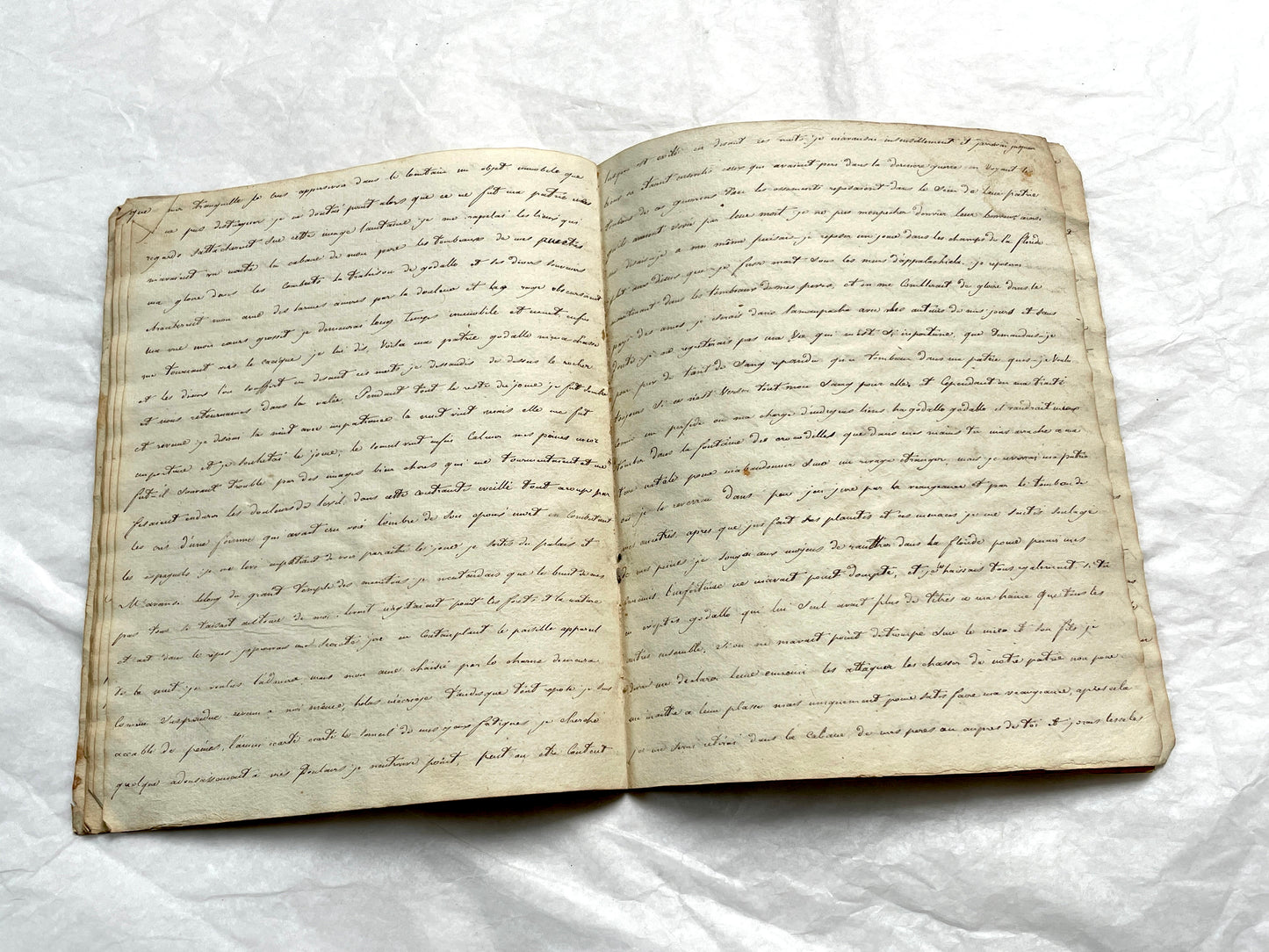 Late 19th Century handwritten French manuscript book with aged pages open to reveal flowing script.