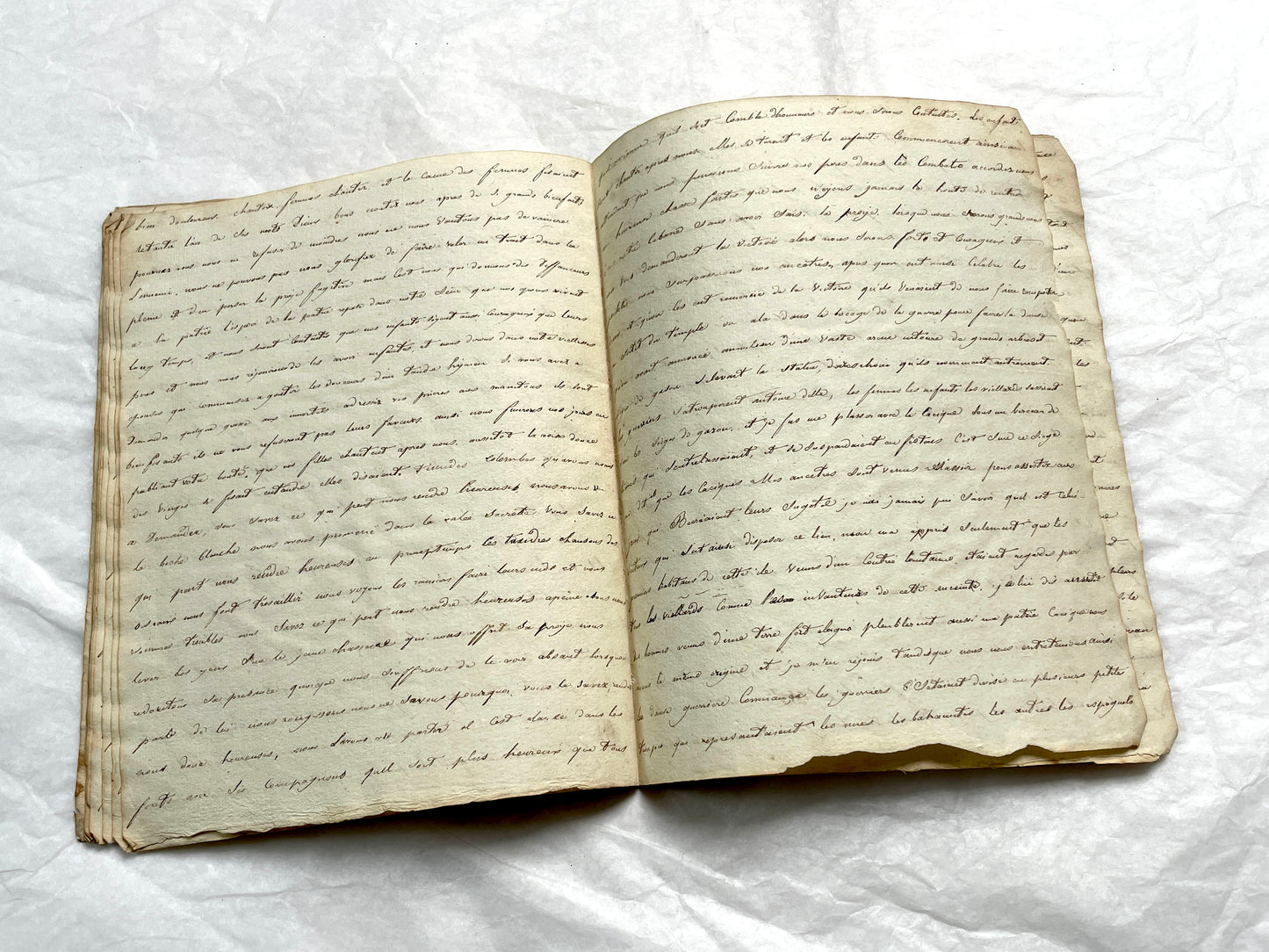 Late 19th Century handwritten French manuscript book with aged pages open to reveal flowing script.