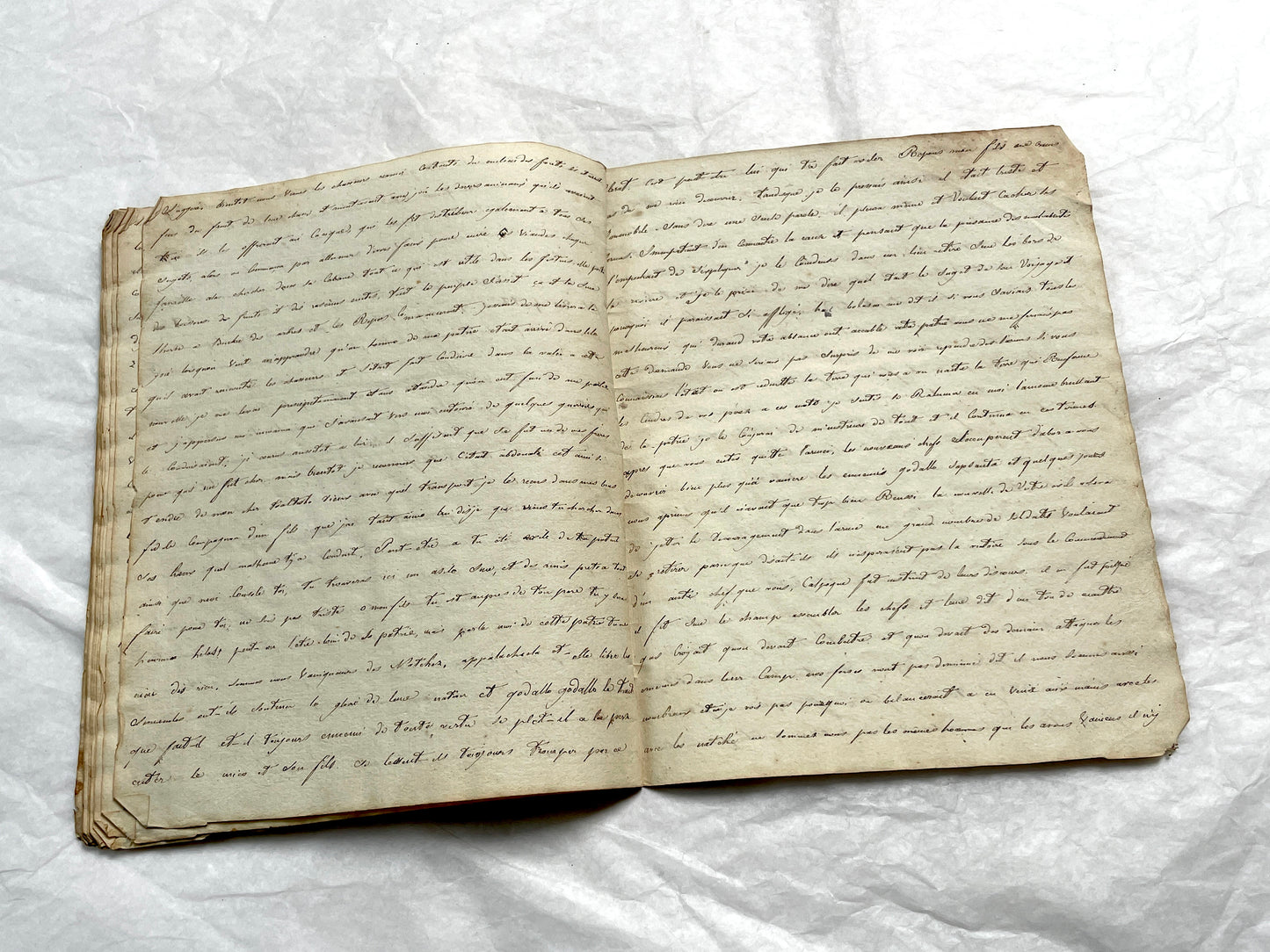 Late 19th Century handwritten French manuscript book with aged pages open to reveal flowing script.