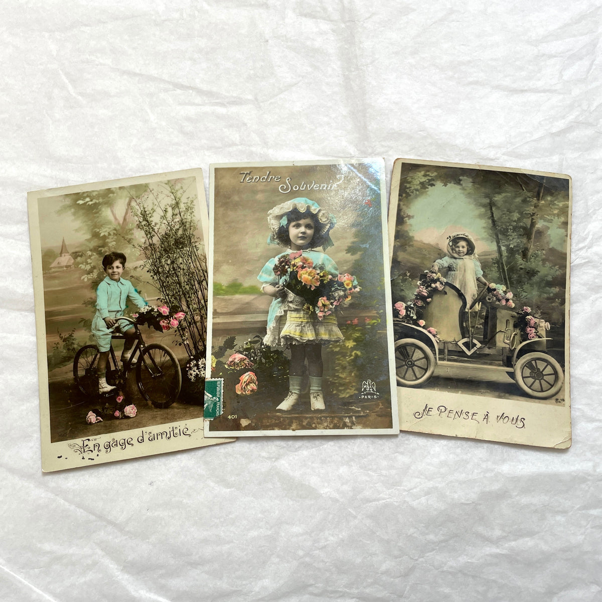 1900s French Postcard Lot featuring charming children on a bicycle, holding flowers, and in an antique car.