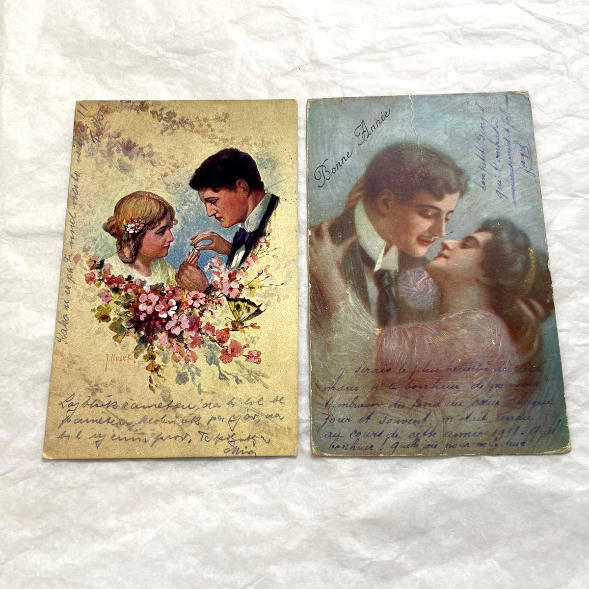 Two 1910s vintage French postcards featuring romantic couples with flowers and New Year greetings.