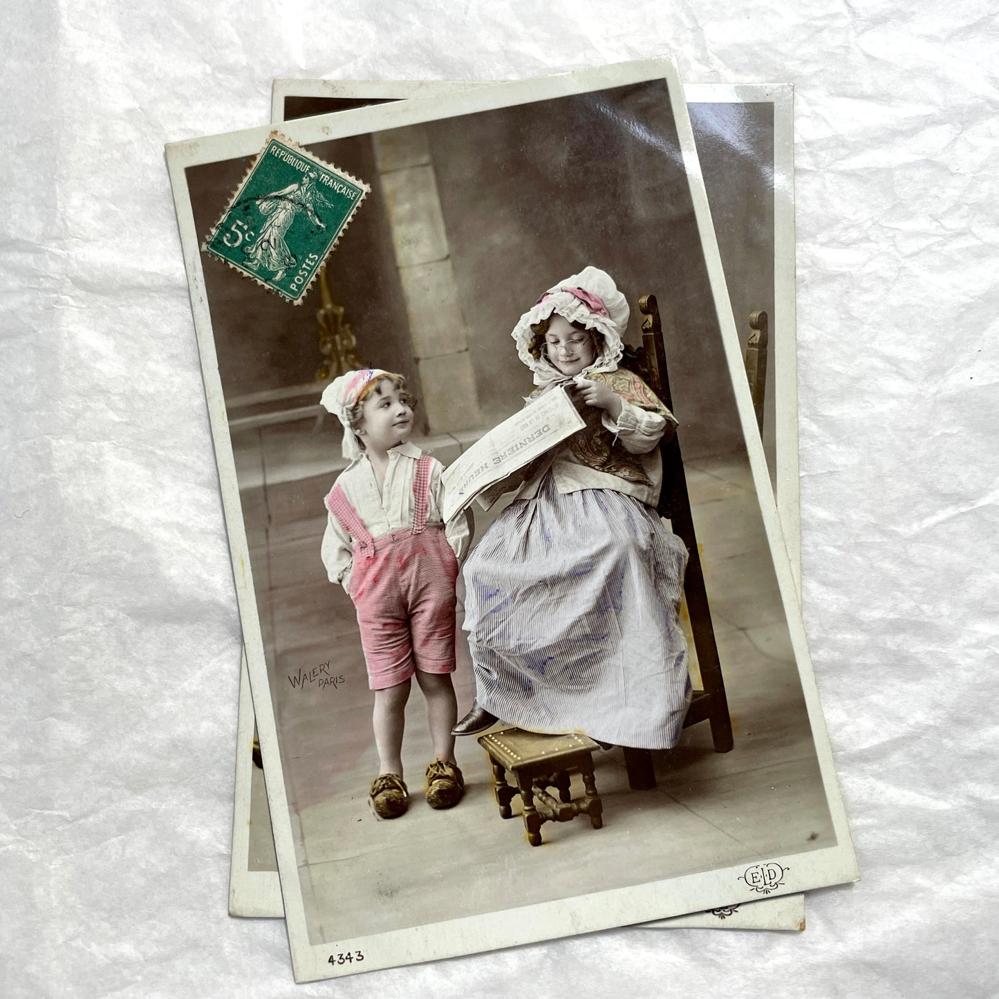1900s French Postcards Lot - Hand-colored images of children with bonnets and newspaper by Walery Paris.