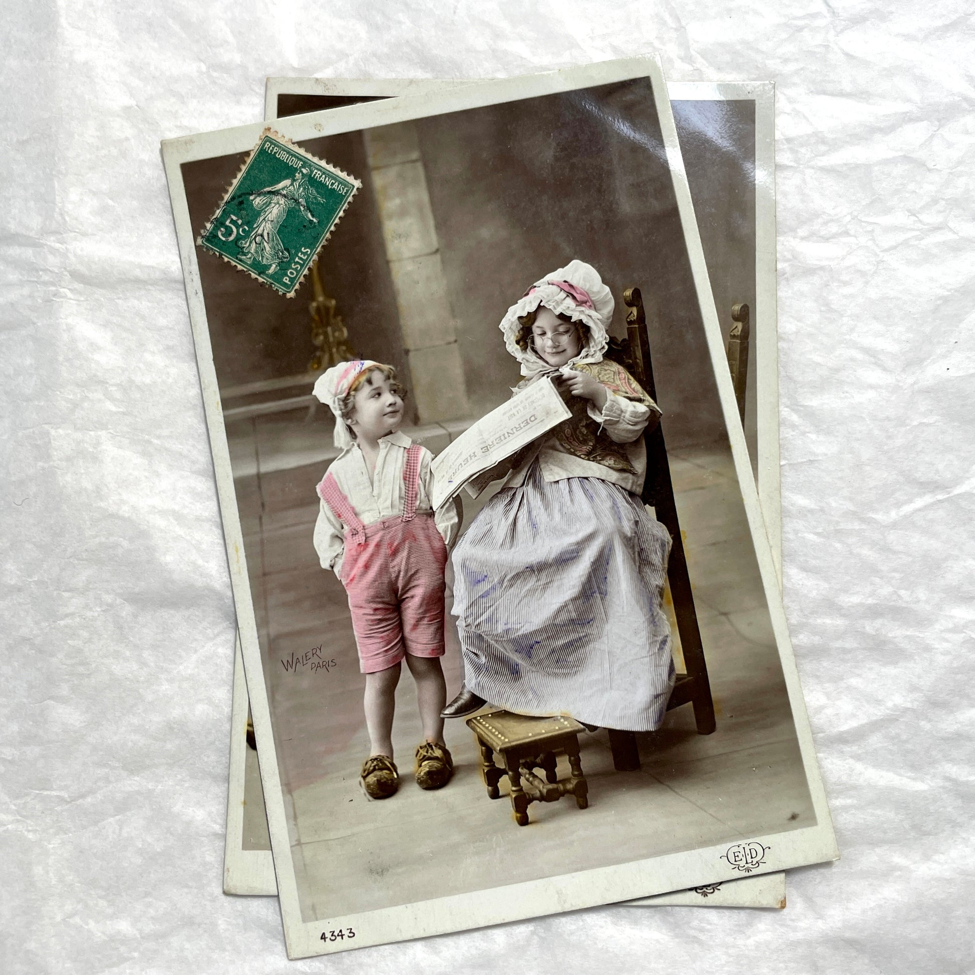 1900s French Postcards Lot - Hand-colored images of children with bonnets and newspaper by Walery Paris.