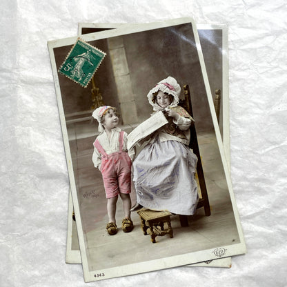1900s French Postcards Lot - Hand-colored images of children with bonnets and newspaper by Walery Paris.