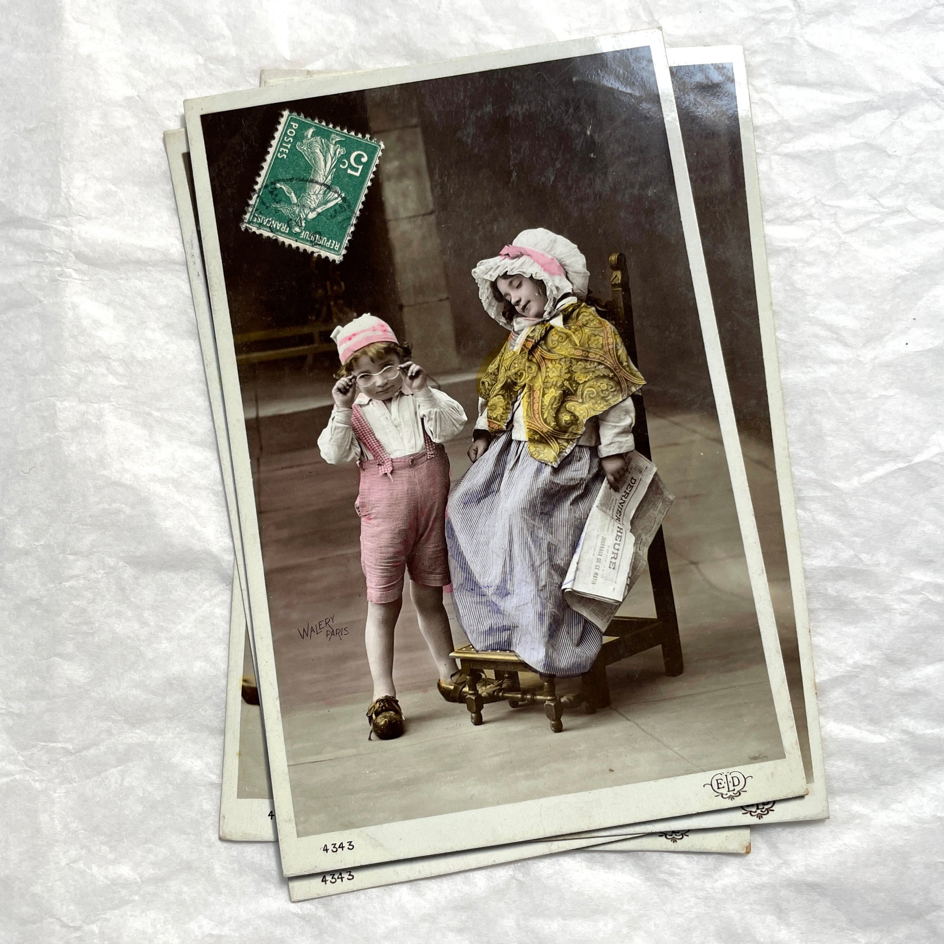1900s French Postcards Lot - Hand-colored images of children with bonnets and newspaper by Walery Paris.