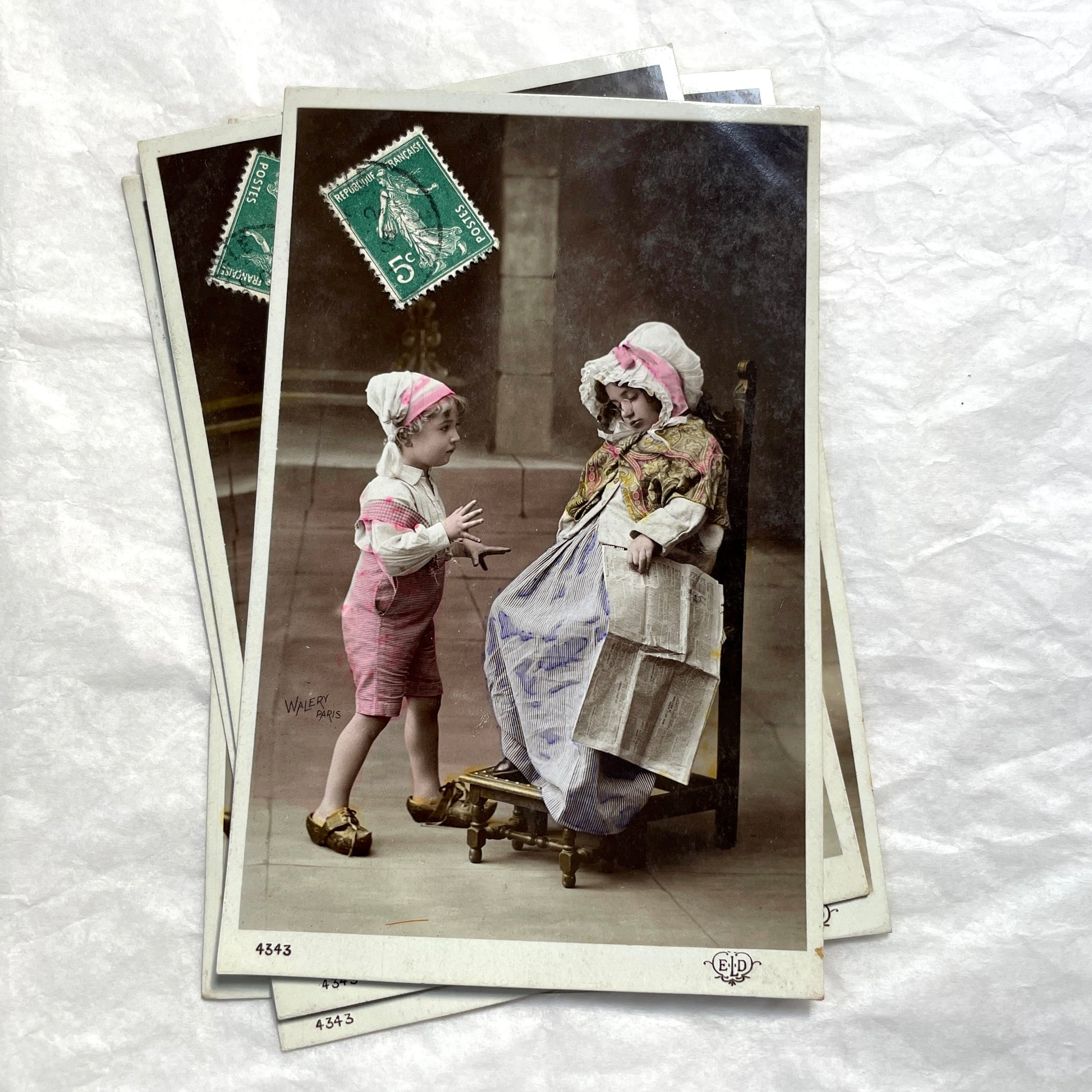 1900s French Postcards Lot - Hand-colored images of children with bonnets and newspaper by Walery Paris.