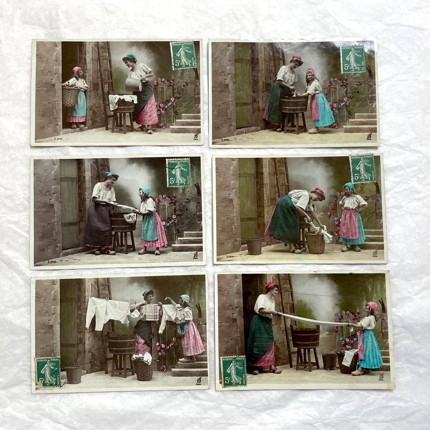 Lot of 6 1910s French postcards depicting women washing laundry in a village setting with visible French stamps.