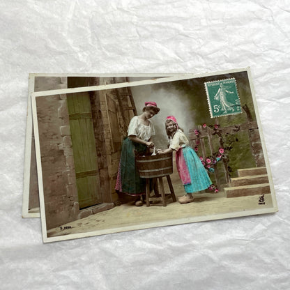 Lot of 6 1910s French postcards depicting women washing laundry in a village setting with visible French stamps.
