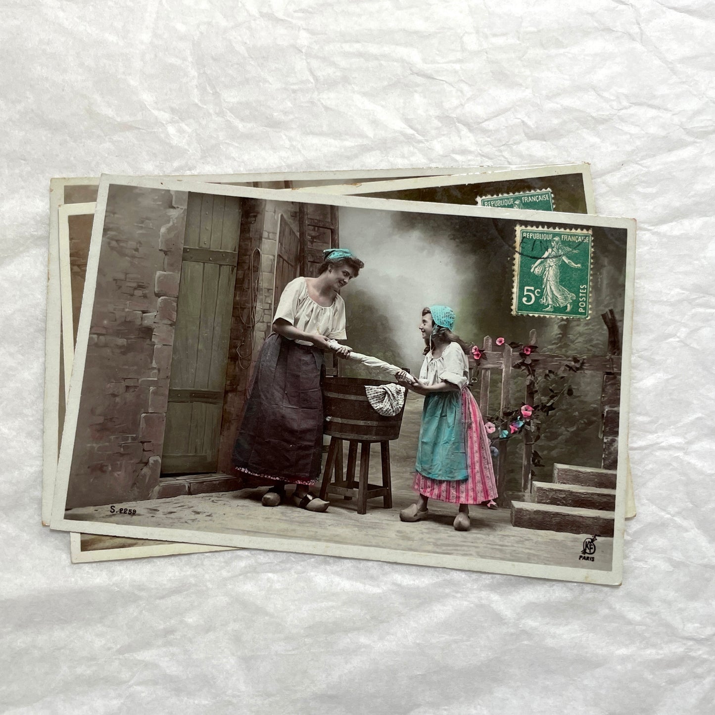 Lot of 6 1910s French postcards depicting women washing laundry in a village setting with visible French stamps.